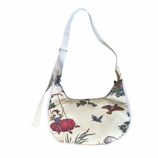 Floral patterned handbag with a strap on a white background