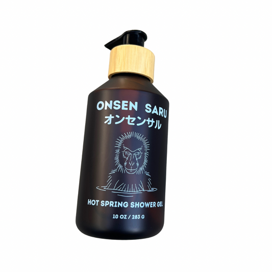 Amber plastic bottle of Onsen Saru hot spring shower gel with a bamboo pump on a white background