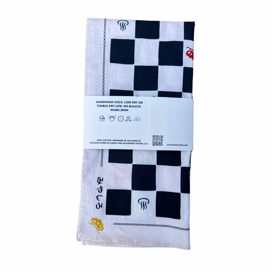Checkered towel with branding and care instructions on a white background