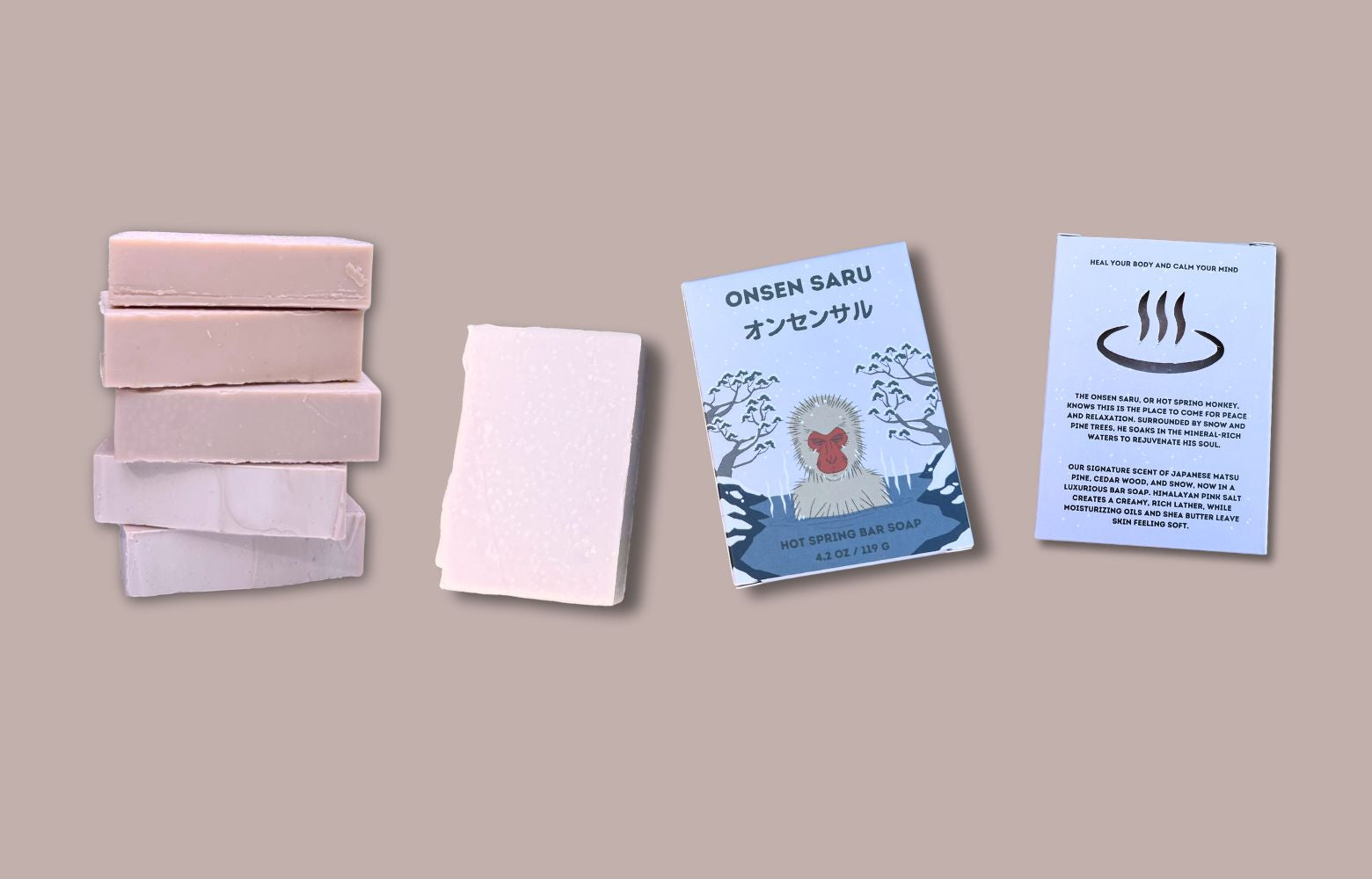 Set of pink soap bars and packaging on a beige background